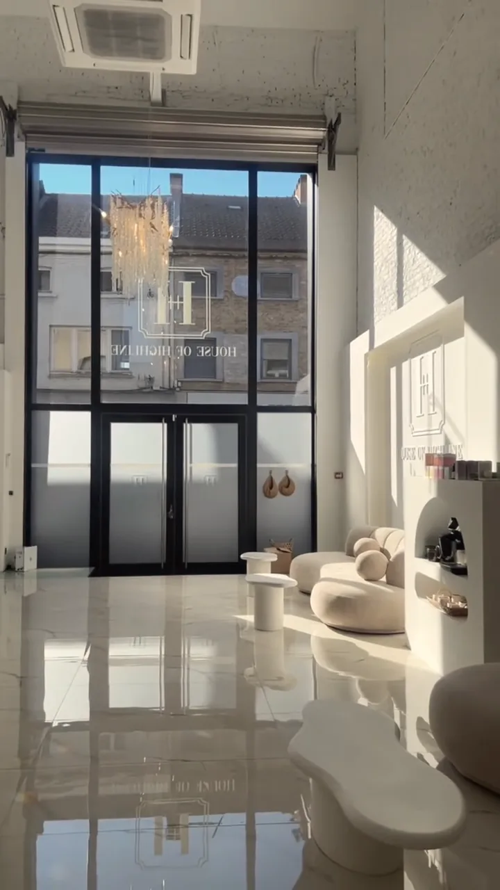 Le hall d’entrée de House of Highline, grande baie vitrée et canapés clairs